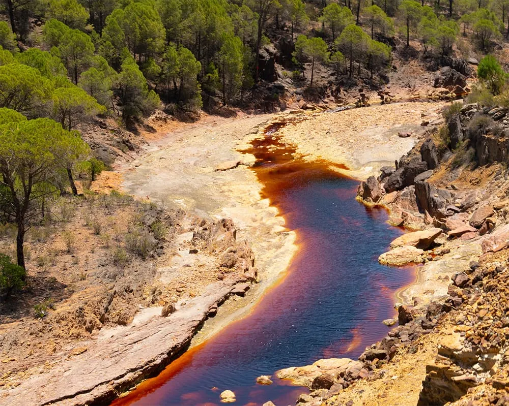 View on a flooded quarry with red water and dried 2026